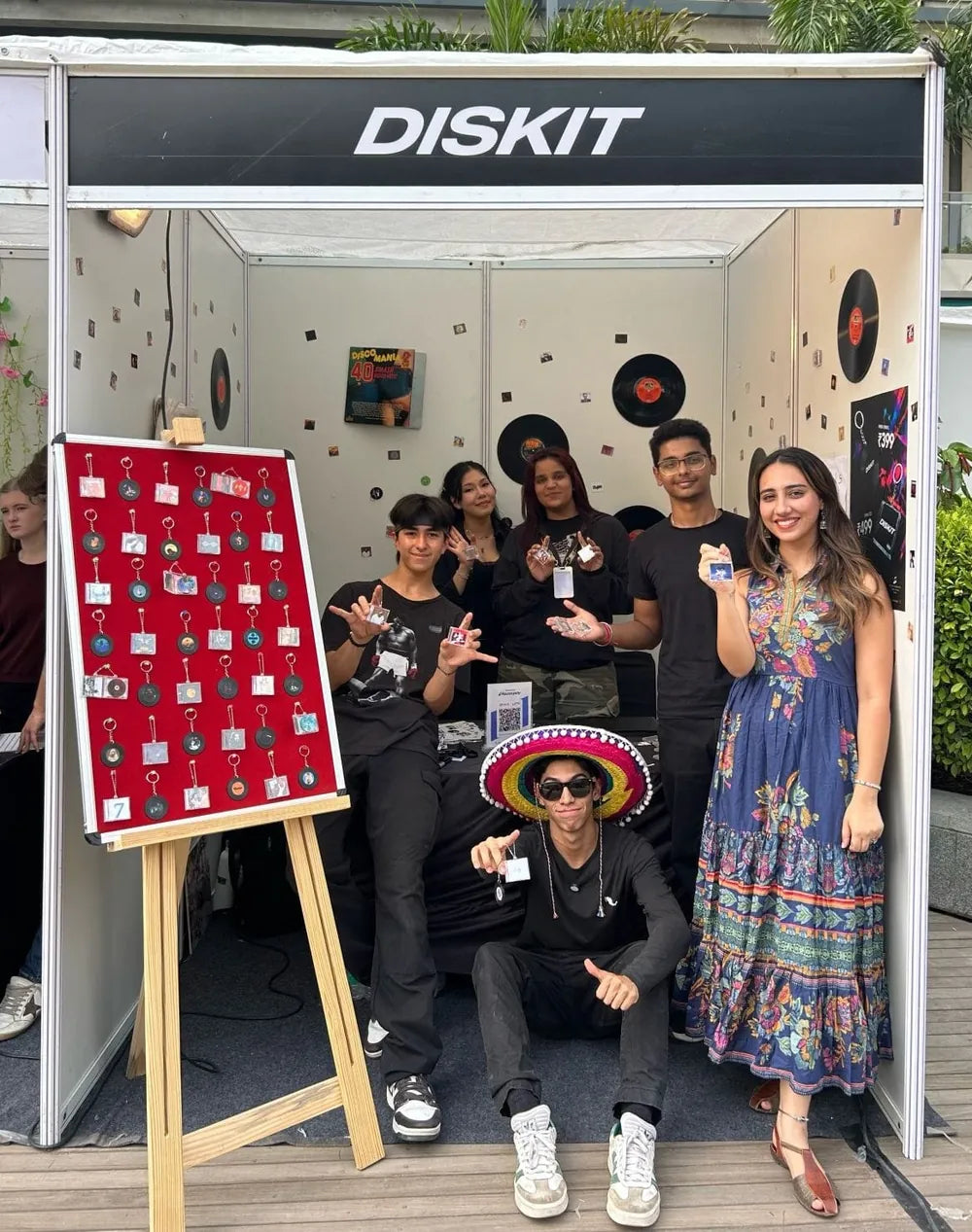 The DISKIT team at our hand-built stall in Delhi, holding up their keychains